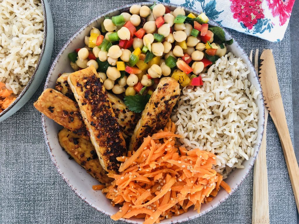 buddha bowl proteico con garbanzos, arroz integral, tempeh y verduras frescas