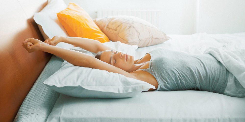 Mujer descansando en la cama representando hábitos saludables y calidad del sueño