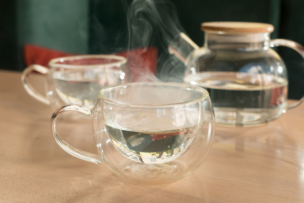 Infusión caliente y agua caliente servidas en tazas de cristal, una opción natural para mantener la hidratación durante el resfriado en invierno