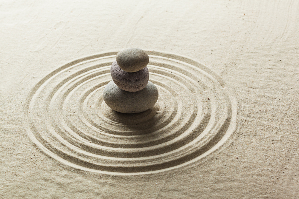 Piedras en equilibrio sobre arena que simbolizan el ikigai, el equilibrio interior y la motivación cotidiana.