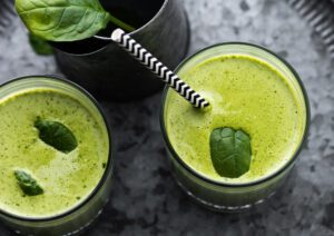 Zumo verde antioxidante suave con espinacas, pepino y limón servido en vaso de cristal