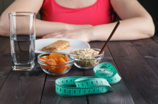 Dieta restrictiva para adelgazar con alimentos simples y cinta métrica, relacionada con hábitos que impiden adelgazar.