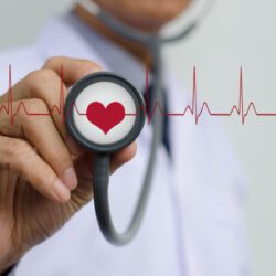 Médico examinando el ritmo cardíaco con estetoscopio ilustrando la relación entre resistencia a la insulina y arritmias cardíacas