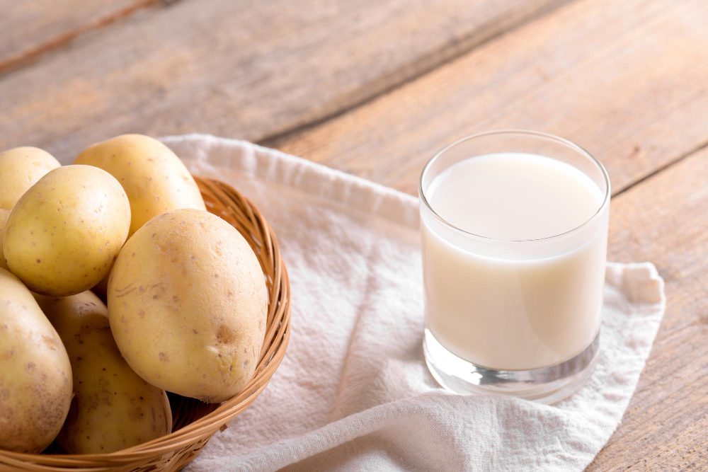zumo de patata cruda para el estómago en vaso con patatas frescas