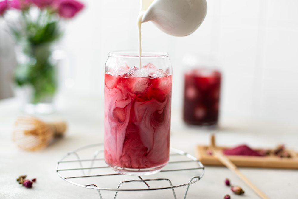 bebida natural de color rojo con leche vertiéndose, remedio digestivo casero con ingredientes naturales