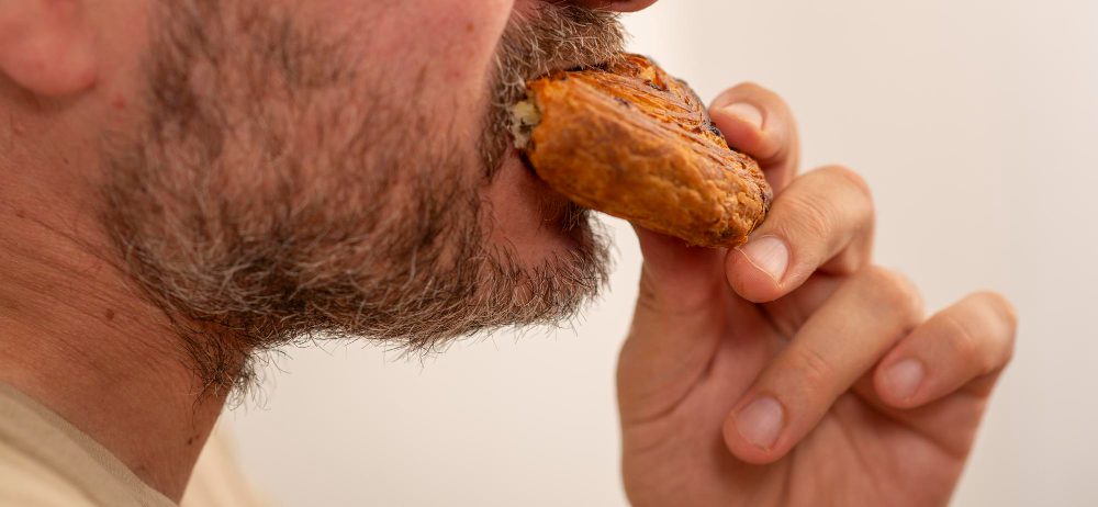 Cadmio en el pan: persona comiendo pan, ejemplo de exposición diaria a metales pesados en la alimentación