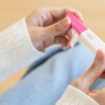 Mujer mirando un test de embarazo relacionado con fertilidad natural y concepción