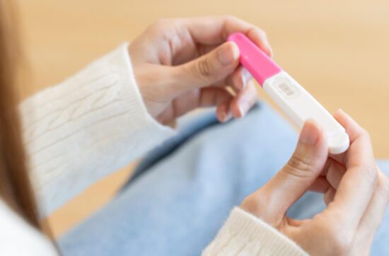 Mujer mirando un test de embarazo relacionado con fertilidad natural y concepción