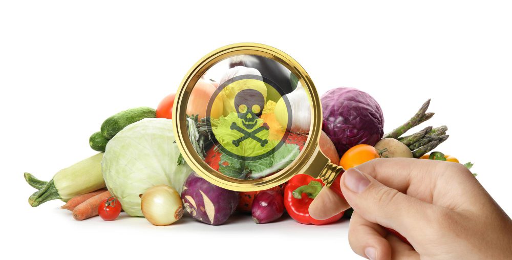 detección de pesticidas en alimentos frescos con lupa y símbolo de toxicidad