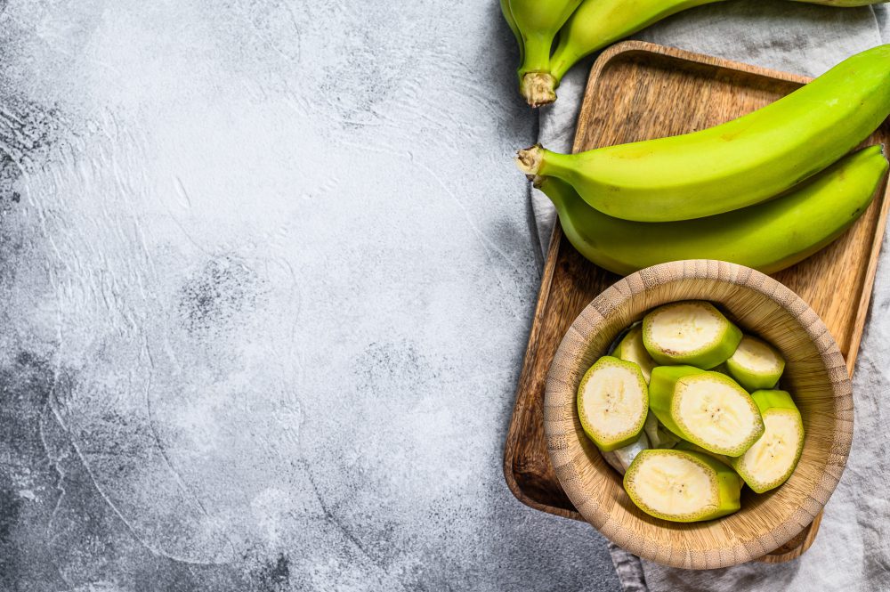 Plátano verde rico en almidón resistente sobre una tabla de madera